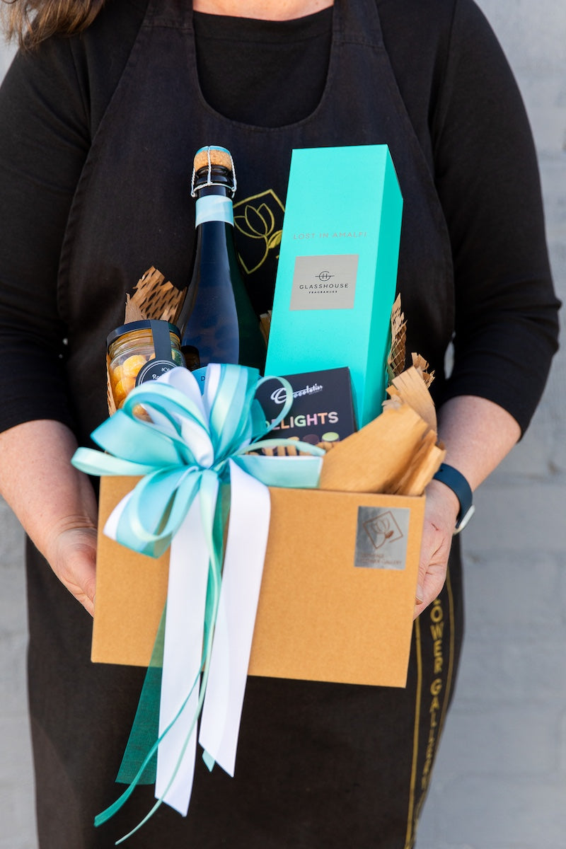 Image of a Donvale Flower Gallery team member holding the Italian Escape gift hamper.