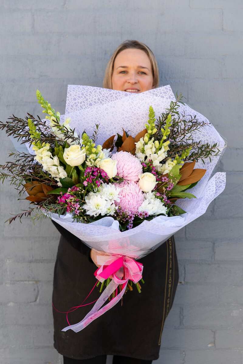 Image of a Donvale Flower Gallery team member holding the Astrid flower arrangement.