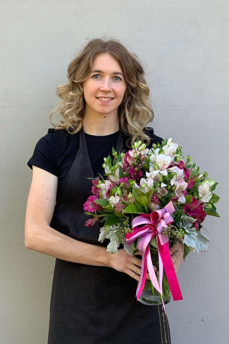 Image of a Donvale Flower Gallery team member holding the Bella flower arrangemetn.