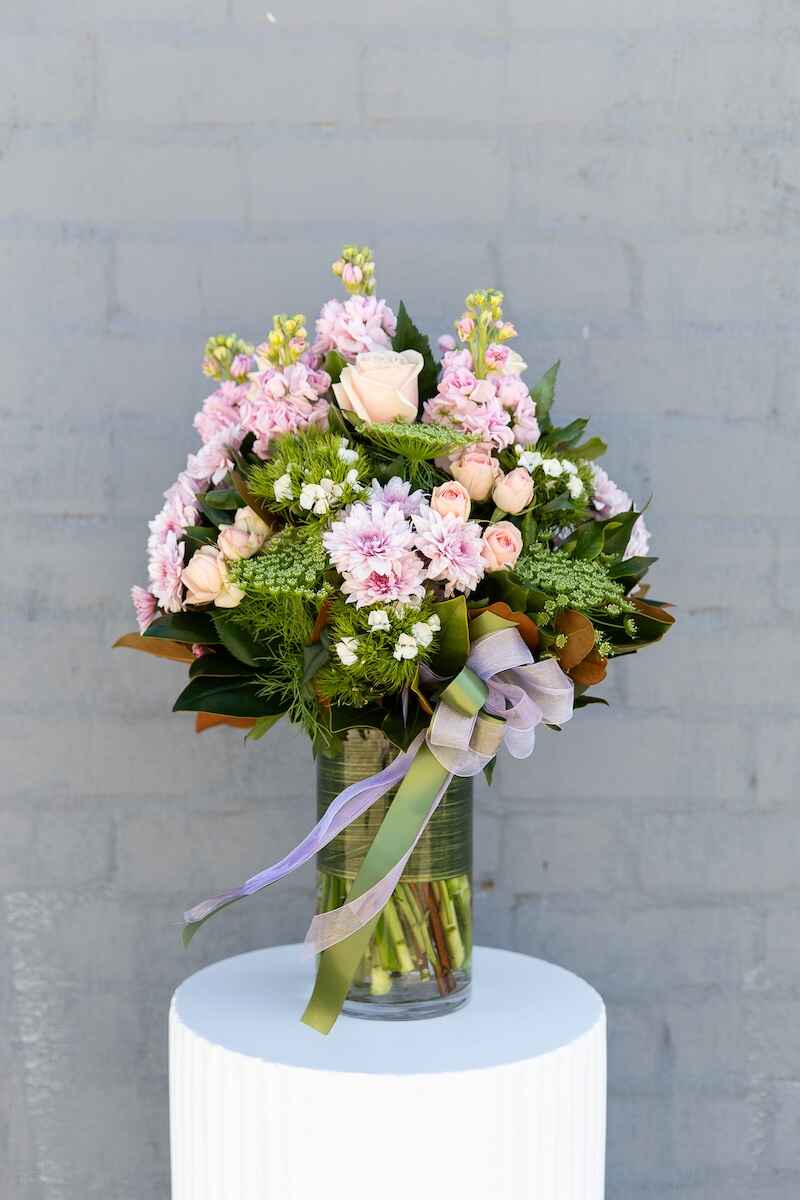 Image of the Delightful flower bouquet - consisting of pink and white blooms with lush foliage. Comes in a leaf-lined glass vase.