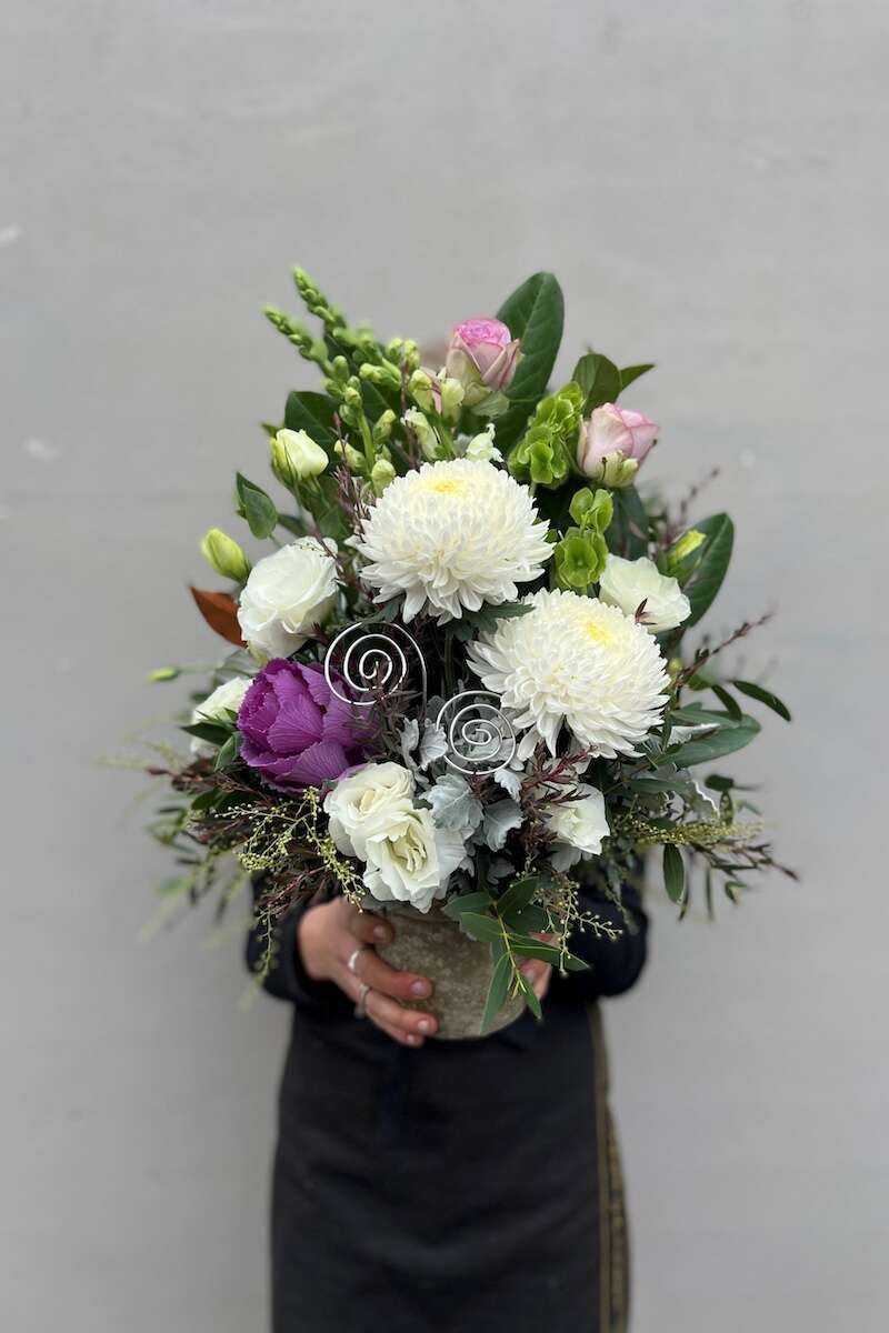 Image of a Donvale Flower Gallery team member holding the Patricia flower arrangement.