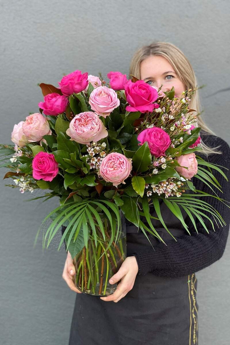 Image of a Donvale Flower Gallery team member holding a Simply Roses bouquet.