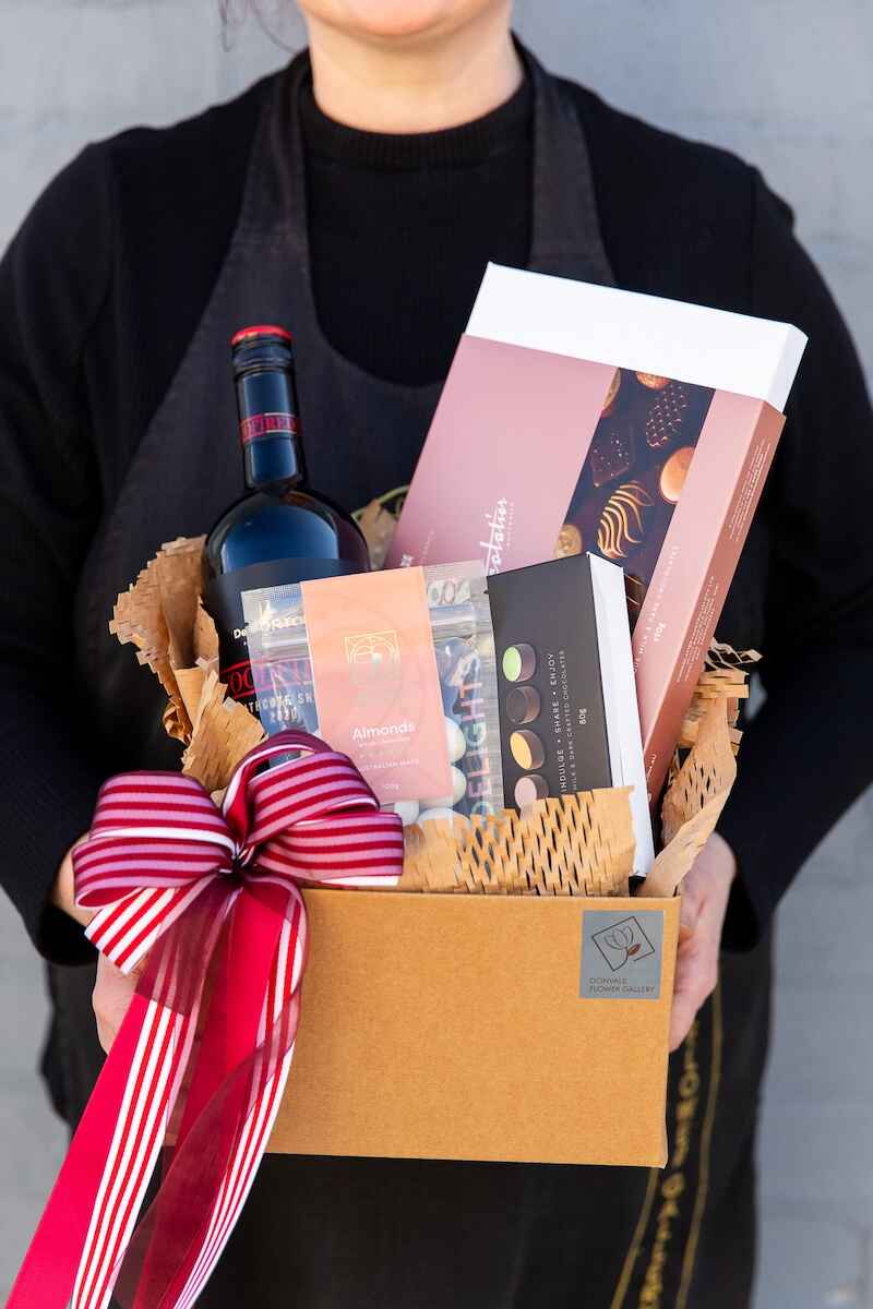 Photo of a Donvale Flower Gallery team member holding the Wine O Choc gift hamper.